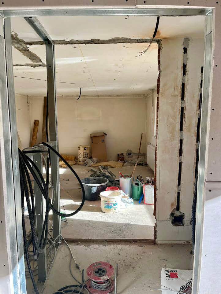 Renovierungsprojekt: Leerer Raum mit Werkzeugen und Kabeln, bereit für Umbauarbeiten im Innenbereich.
