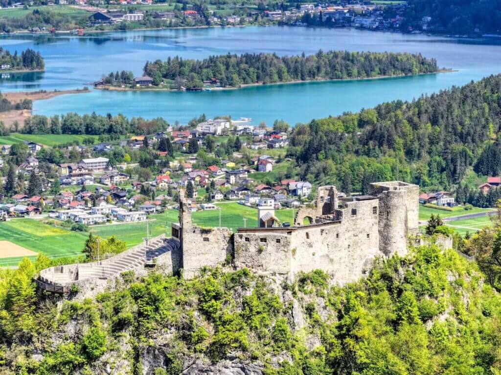 Mittelalterliche Burg mit Blick auf blauen See und grüne Landschaft, ideal für historische Fotografie und Tourismus.
