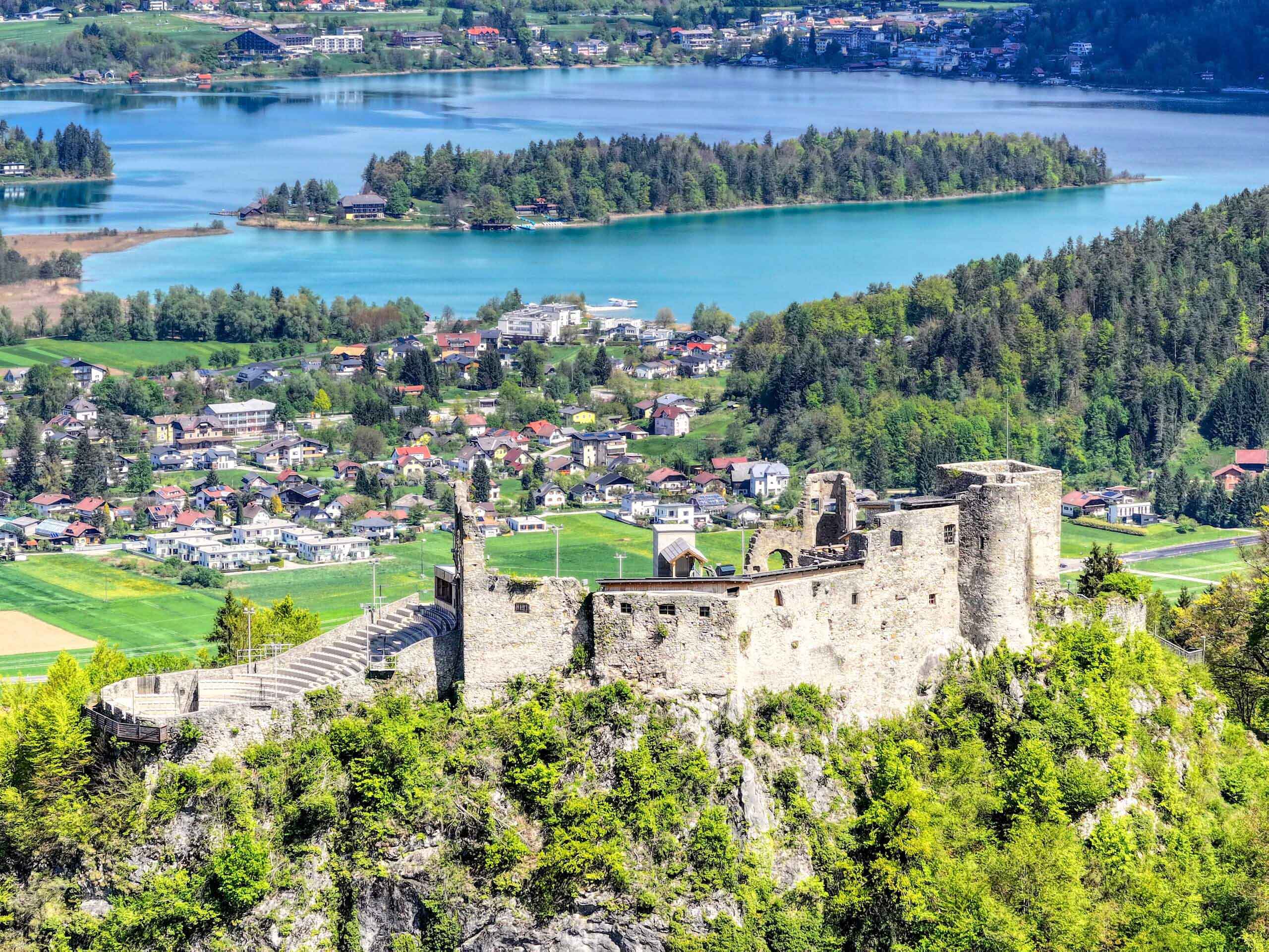 Mittelalterliche Burg mit Blick auf blauen See und grüne Landschaft, ideal für historische Fotografie und Tourismus.