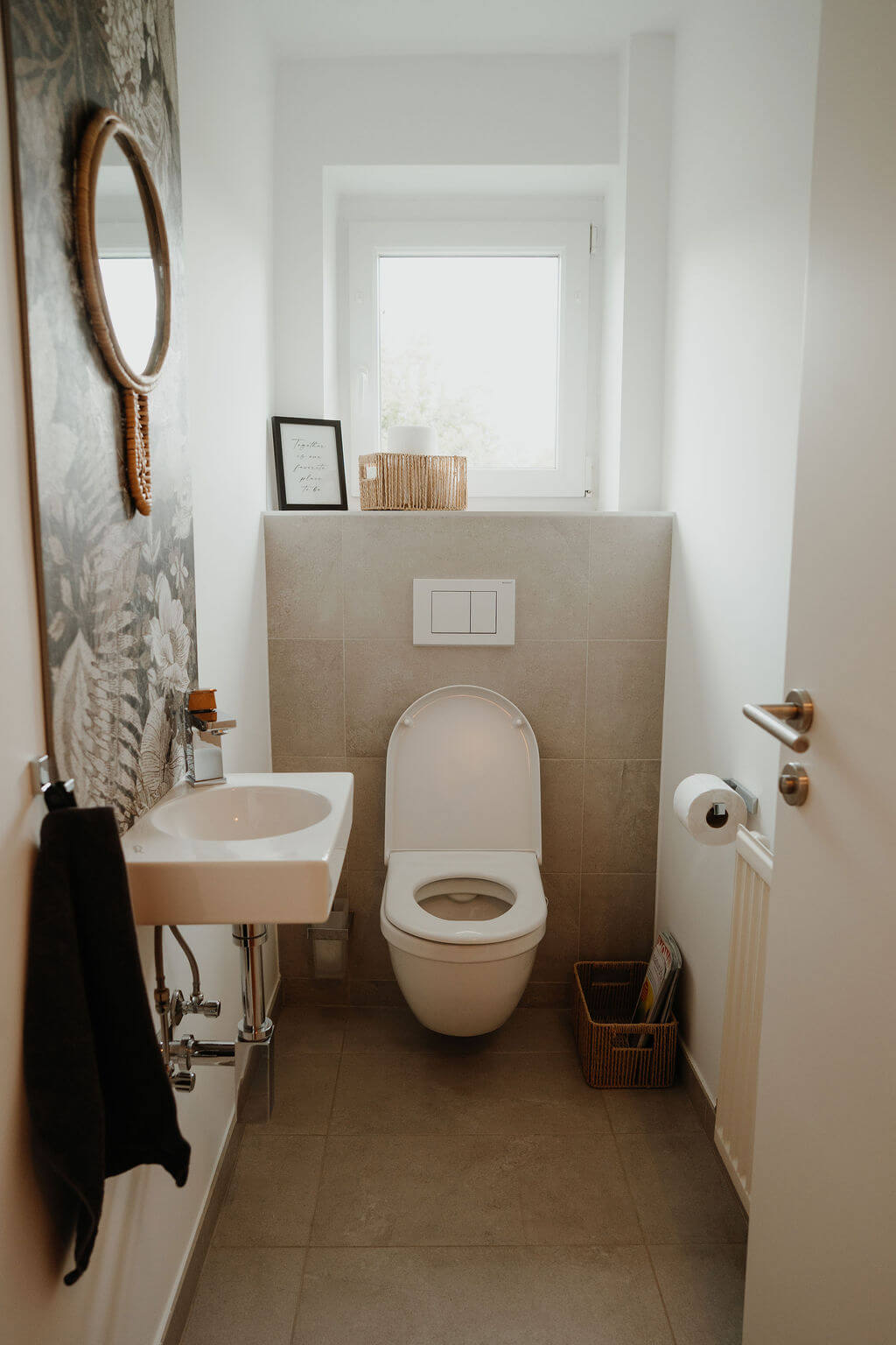 Modernes Badezimmer mit hängendem WC, kleinem Waschbecken und stilvollem Dekor. Perfekt für minimalistische Designs.