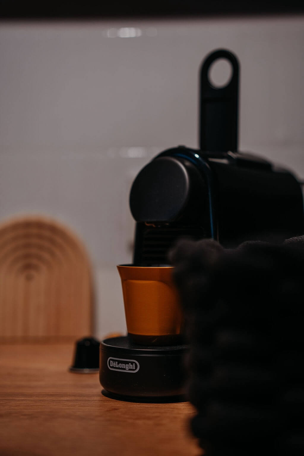 Kompakte DeLonghi Kaffeekapselmaschine in einer Küche, bereit für köstlichen Espresso. Ideal für Kaffeeliebhaber.
