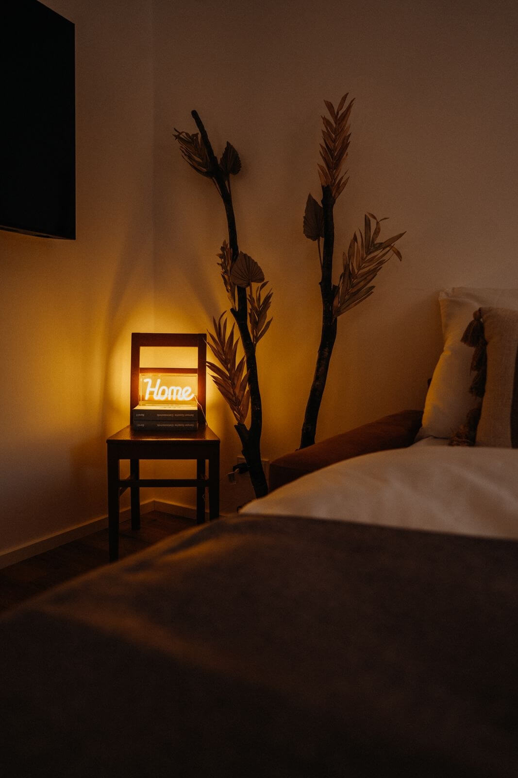 Gemütliches Schlafzimmer mit warmem Licht, dekorativer Beleuchtung und Pflanzen. Ideal für Ruhe und Entspannung.